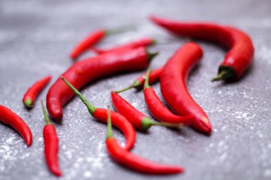 Kırmızı biber ve yeşil biber, gri masaya yayılmış sarımsak mutfakta pişirmeye hazır..