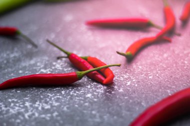 Kırmızı biber ve yeşil biber, gri masaya yayılmış sarımsak mutfakta pişirmeye hazır..