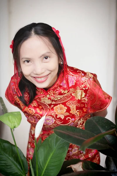 Mulher Asiática Vermelho Vestido Chinês Fundo Frente Flores Folhas Verdes — Fotografia de Stock