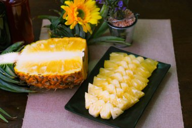 Asya 'nın ahşap arka planında ananas dilimleri ve ananas kabuklu Asya tarzı..