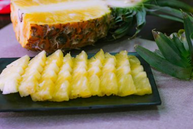 Asya 'nın ahşap arka planında ananas dilimleri ve ananas kabuklu Asya tarzı..