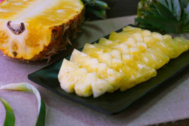 Asya 'nın ahşap arka planında ananas dilimleri ve ananas kabuklu Asya tarzı..