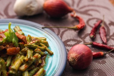 Kızarmış domuz eti ve kırmızı köri ezmesini mavi bir tabakta ahşap bir masada servis edilmiş soya fasulyesiyle karıştır. Tayland 'da bir sokak yemeği..