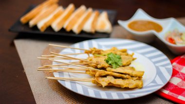 Pork satay - Fıstık soslu veya tatlı ızgara domuz eti, ekşi sos ve tost, Tayland sokak yemeği ve Tayland 'daki restoranda lezzetli yemekler.