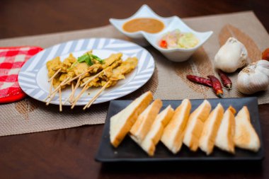 Pork satay - Fıstık soslu veya tatlı ızgara domuz eti, ekşi sos ve tost, Tayland sokak yemeği ve Tayland 'daki restoranda lezzetli yemekler.