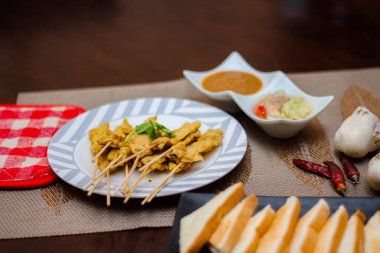 Pork satay - Fıstık soslu veya tatlı ızgara domuz eti, ekşi sos ve tost, Tayland sokak yemeği ve Tayland 'daki restoranda lezzetli yemekler.