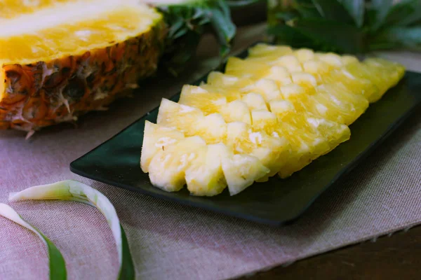 Asya 'nın ahşap arka planında ananas dilimleri ve ananas kabuklu Asya tarzı..