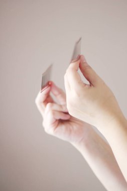 Bir kadının eli 35 mm 'lik bir film tutuyor ve odanın dışındaki ışıkta parlıyor..