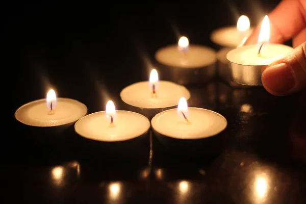 Mann Zündet Mehrere Kerzen Auf Holztisch — Stockfoto