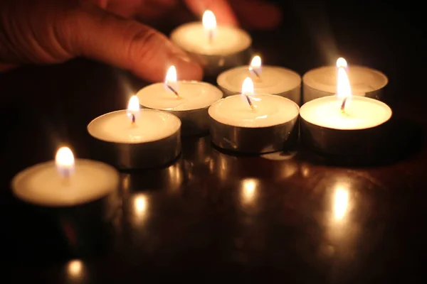 Mão Homem Acendendo Várias Velas Uma Mesa Madeira — Fotografia de Stock