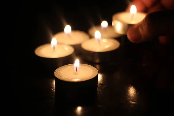 Mann Zündet Mehrere Kerzen Auf Holztisch — Stockfoto