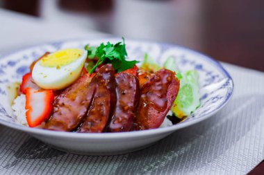 Kızarmış domuz etli pilav haşlanmış yumurta ve üstüne de tatlı sos..