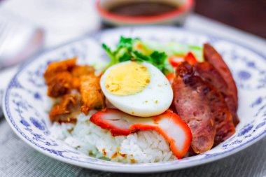 Kızarmış domuz etli pilav haşlanmış yumurta ve üstüne de tatlı sos..