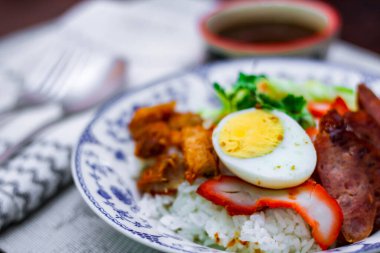 Kızarmış domuz etli pilav haşlanmış yumurta ve üstüne de tatlı sos..