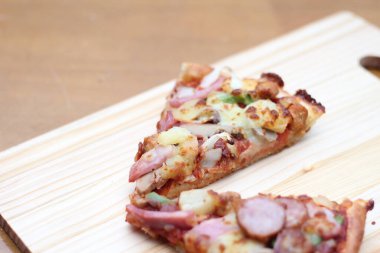 Tahta bir masada, tahta bir tepside servis edilen 2 pizza..