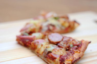 Tahta bir masada, tahta bir tepside servis edilen 2 pizza..
