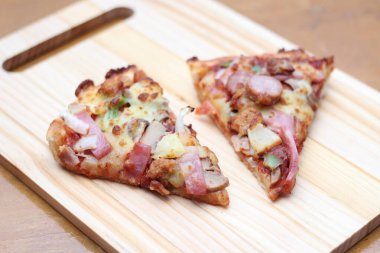 Tahta bir masada, tahta bir tepside servis edilen 2 pizza..