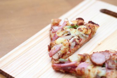 Tahta bir masada, tahta bir tepside servis edilen 2 pizza..