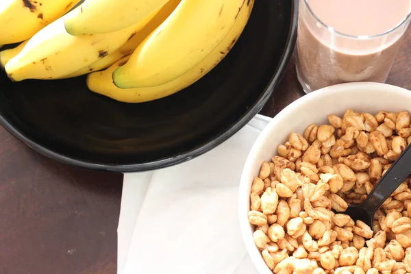Cereal Uma Xícara Branca Bananas Colocadas Uma Mesa Madeira Vista — Fotografia de Stock