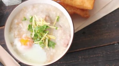 Siyah ahşap bir masada servis edilen Tayland usulü bir fincanda şaka ya da congee. Asya kahvaltısı. en üstteki görünümde