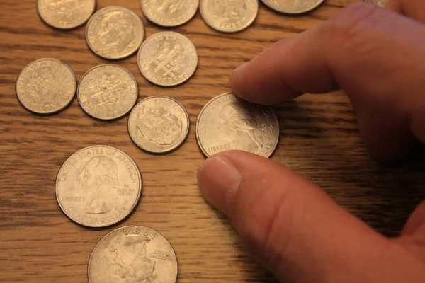 Hand Picking Quarter Coin American Currency Spread Wooden Floor Royalty Free Stock Photos
