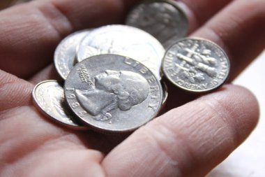 Çeyreklikler ve bozuk paralar Amerika 'nın para birimidir. Erkeklerin ellerinde..