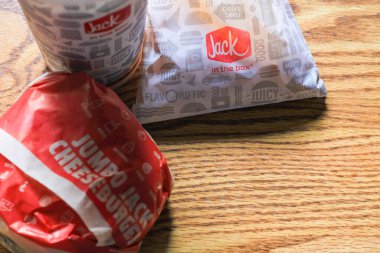 WASHINGTON, ABD - 15 Mart 2022 Hamburgerdeki Jack, kahverengi ahşap bir masada servis edilen patates kızartması ve bardaklar.