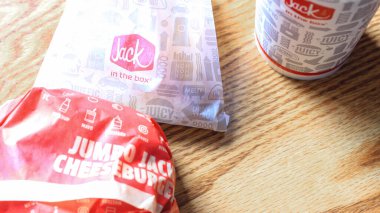 WASHINGTON, ABD - 15 Mart 2022 Hamburgerdeki Jack, kahverengi ahşap bir masada servis edilen patates kızartması ve bardaklar.