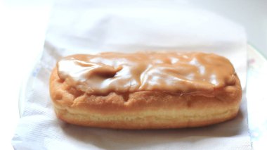Apple Bar, Maple Bar Donut, Maple Bar Donut beyaz bir tabakta servis edilir..