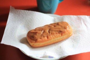Apple Bar, Maple Bar Donut, Maple Bar Donut turuncu bir masada servis ediliyor..