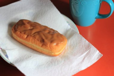 Apple Bar, Maple Bar Donut, Maple Bar Donut turuncu bir masada servis ediliyor..