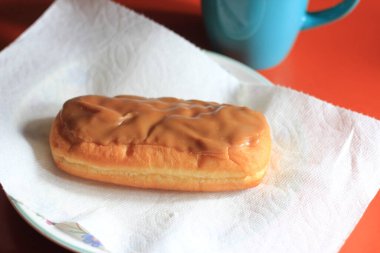 Apple Bar, Maple Bar Donut, Maple Bar Donut turuncu bir masada servis ediliyor..