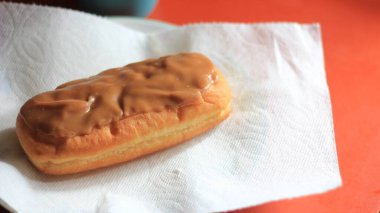 Apple Bar, Maple Bar Donut, Maple Bar Donut turuncu bir masada servis ediliyor..