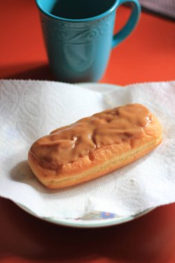 Apple Bar, Maple Bar Donut, Maple Bar Donut turuncu bir masada servis ediliyor..