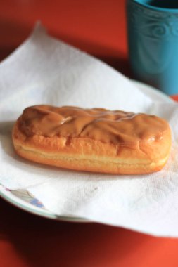Apple Bar, Maple Bar Donut, Maple Bar Donut turuncu bir masada servis ediliyor..