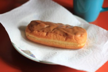 Apple Bar, Maple Bar Donut, Maple Bar Donut turuncu bir masada servis ediliyor..