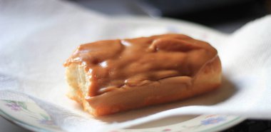 Apple Bar, Maple Bar Donut, Maple Bar Donut beyaz bir tabakta ikiye bölünmüş..