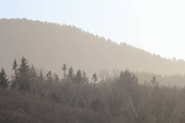 Dağların silueti sabah karmaşık turuncu renkte.