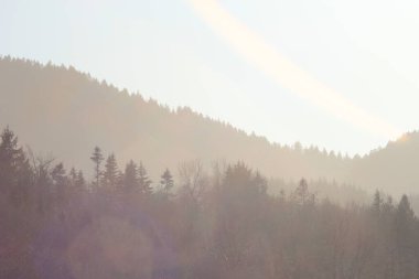 Dağların silueti sabah karmaşık turuncu renkte.