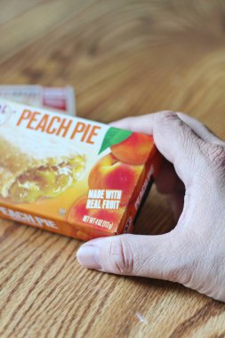 Seattle, ABD - Nisan 07 2022: JJ 'in fırınının şeftalili turtası, ahşap bir masada çilekli ve kremalı turta, aperatif olarak turta. Amerika 'da popüler.