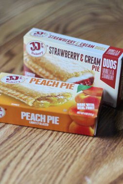 Seattle, ABD - Nisan 07 2022: JJ 'in fırınının şeftalili turtası, ahşap bir masada çilekli ve kremalı turta, aperatif olarak turta. Amerika 'da popüler.