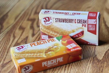 Seattle, ABD - Nisan 07 2022: JJ 'in fırınının şeftalili turtası, ahşap bir masada çilekli ve kremalı turta, aperatif olarak turta. Amerika 'da popüler.