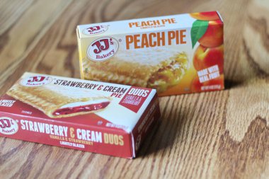 Seattle, ABD - Nisan 07 2022: JJ 'in fırınının şeftalili turtası, ahşap bir masada çilekli ve kremalı turta, aperatif olarak turta. Amerika 'da popüler.