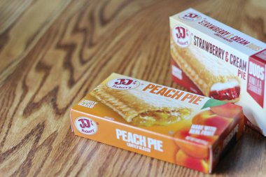 Seattle, ABD - Nisan 07 2022: JJ 'in fırınının şeftalili turtası, ahşap bir masada çilekli ve kremalı turta, aperatif olarak turta. Amerika 'da popüler.