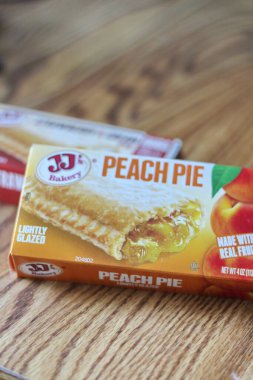 Seattle, ABD - Nisan 07 2022: JJ 'in fırınının şeftalili turtası, ahşap bir masada çilekli ve kremalı turta, aperatif olarak turta. Amerika 'da popüler.