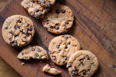 Tahta masaya yerleştirilmiş lezzetli çikolatalı kurabiyeler.