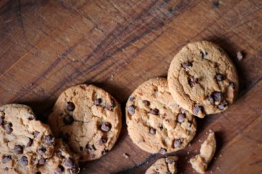 Tahta masaya yerleştirilmiş lezzetli çikolatalı kurabiyeler.