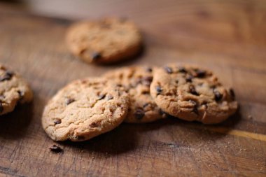 Tahta masaya yerleştirilmiş lezzetli çikolatalı kurabiyeler.