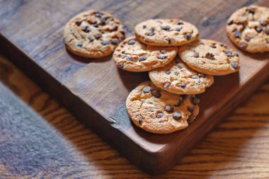Tahta kesme tahtasında servis edilen taze pişmiş çikolatalı kurabiyeler..