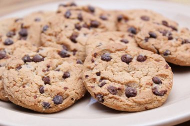 Çikolatalı kurabiyeler açık kahverengi bir tabakta hazırlanır ve çocuklara servis edilmeye hazırdır..